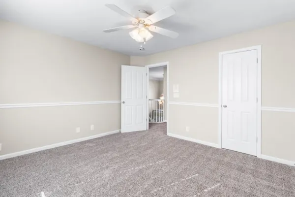a view of an empty room with a ceiling fan