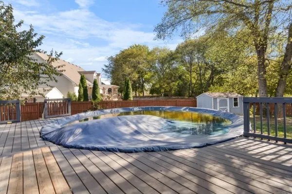 a view of backyard with swimming pool and seating space