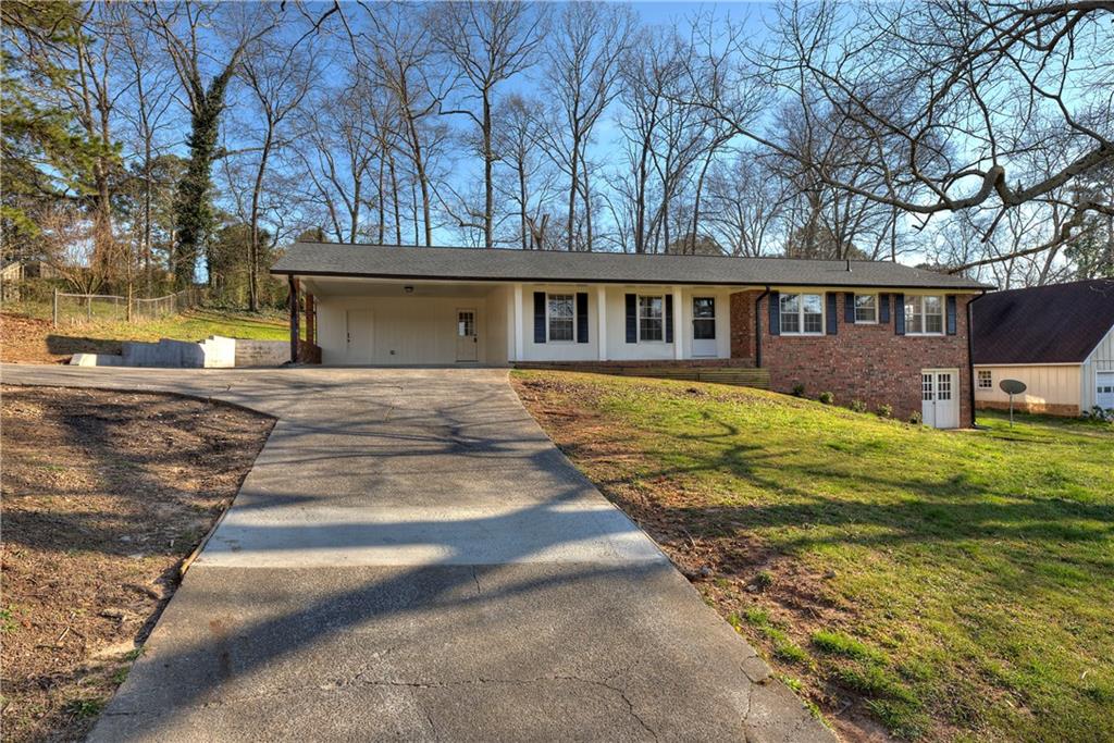 a front view of house with yard and trees in the background