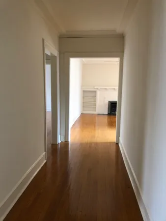 a view of a room with wooden floor and a window