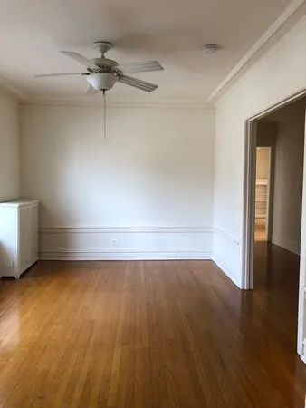 a view of a room with wooden floors and white walls