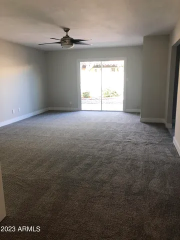 an empty room with windows and a ceiling fan