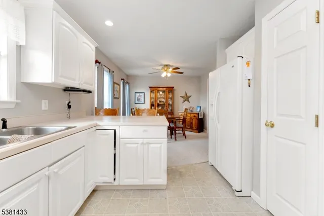 a kitchen with white cabinets and sink