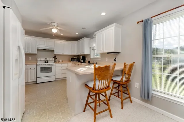 a kitchen with stainless steel appliances granite countertop a stove a sink a microwave oven with a dining table and chairs