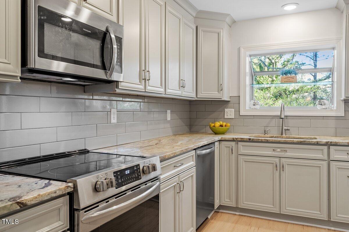 205 Clancy Circle Cary, NC 27511 - Photo 21 of 36 a kitchen with stainless steel appliances granite countertop a sink a stove and microwave