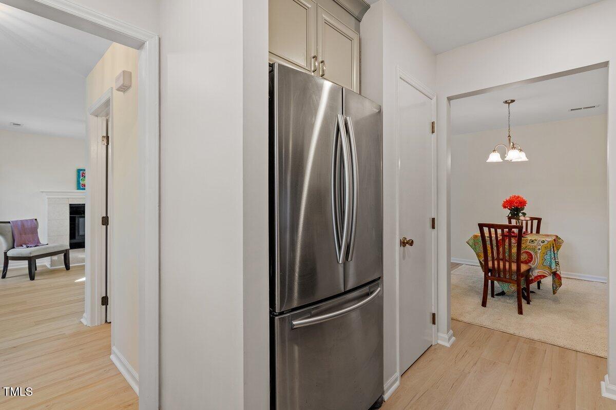 205 Clancy Circle Cary, NC 27511 - Photo 23 of 36 a kitchen with refrigerator a dining table and chairs