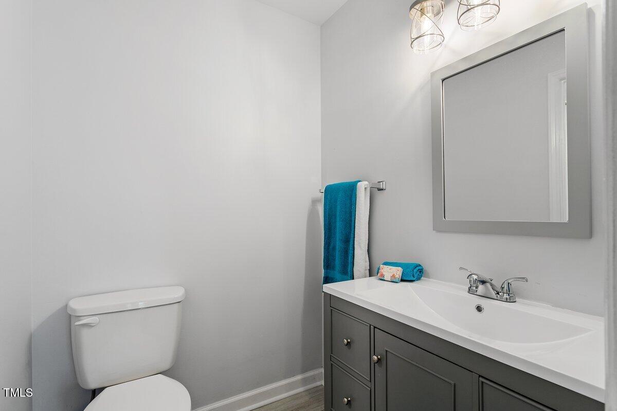 205 Clancy Circle Cary, NC 27511 - Photo 29 of 36 a bathroom with a toilet sink vanity and mirror