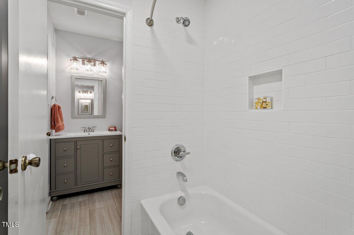 205 Clancy Circle Cary, NC 27511 - Photo 30 of 36 a bathroom with a tub sink and mirror