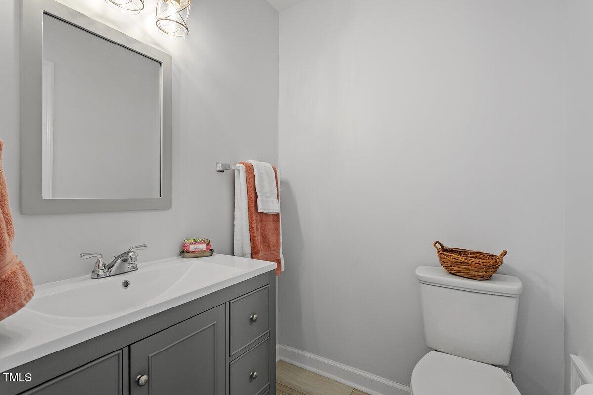 205 Clancy Circle Cary, NC 27511 - Photo 31 of 36 a bathroom with a toilet sink vanity and mirror