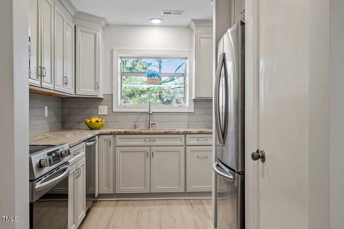 205 Clancy Circle Cary, NC 27511 - Photo 34 of 36 a kitchen with stainless steel appliances granite countertop a sink and a refrigerator