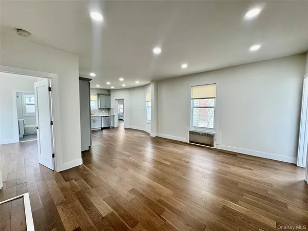 a view of a big room with wooden floors and a window