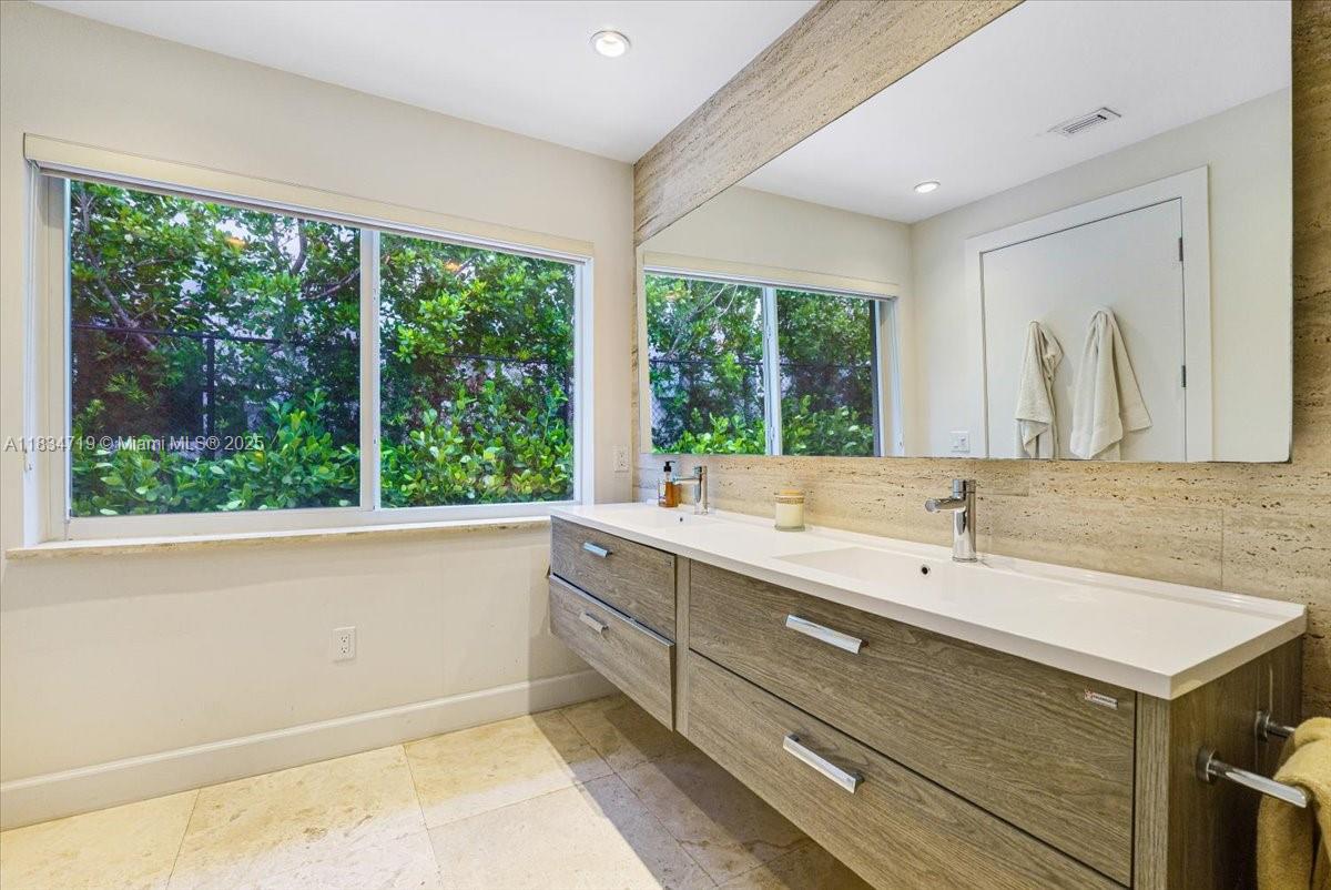 435 Ridgewood Road Key Biscayne, FL 33149 - Photo 17 of 32 a bathroom with a sink and a large mirror next to a window