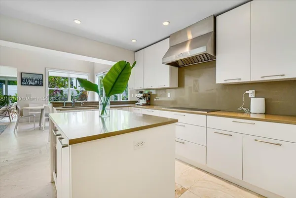 a kitchen with stainless steel appliances kitchen island granite countertop a sink a stove and cabinets