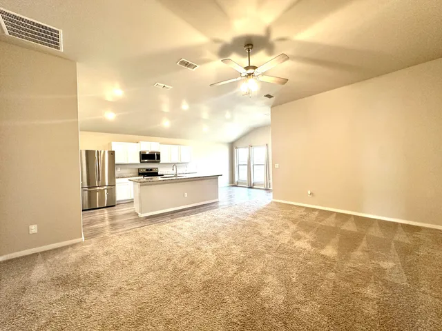 a view of a kitchen with wooden cabinet and a refrigerator