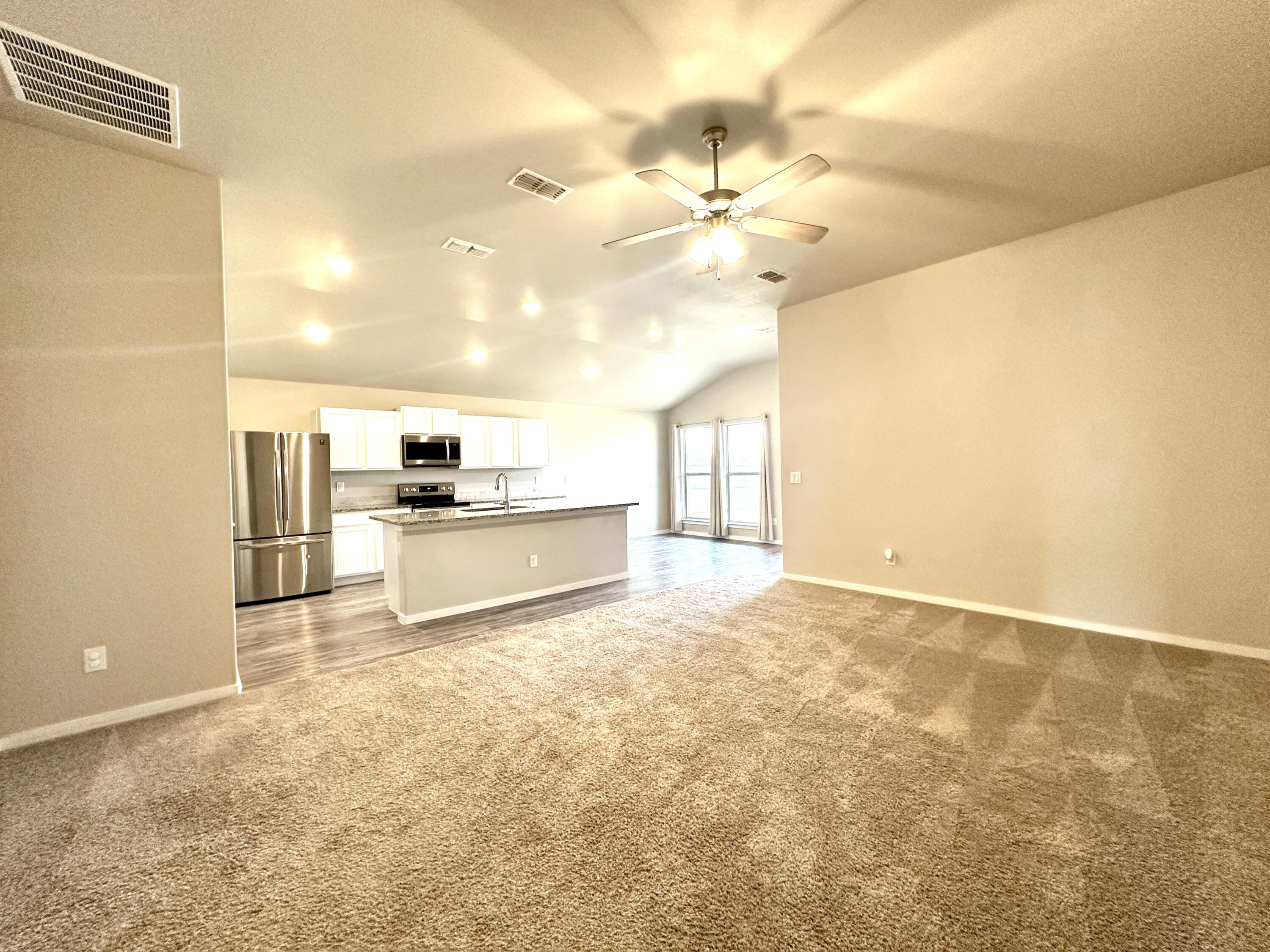 7526 31st Place Lubbock, TX 79407 - Photo 2 of 14 a view of a kitchen with wooden cabinet and a refrigerator