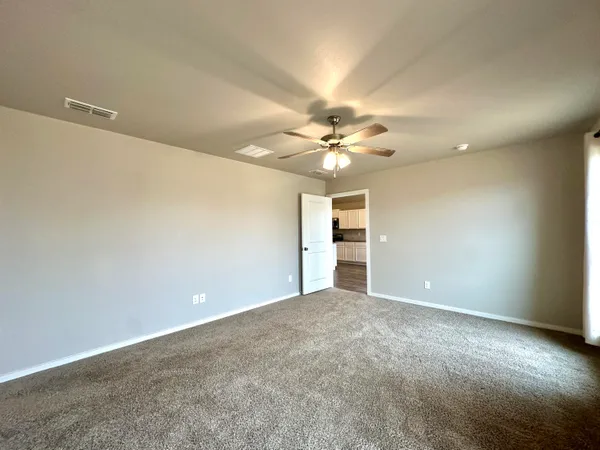 a view of an empty room with a chandelier fan