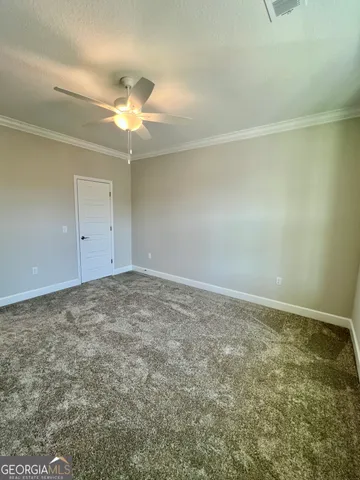 an empty room with a fan & a ceiling fan