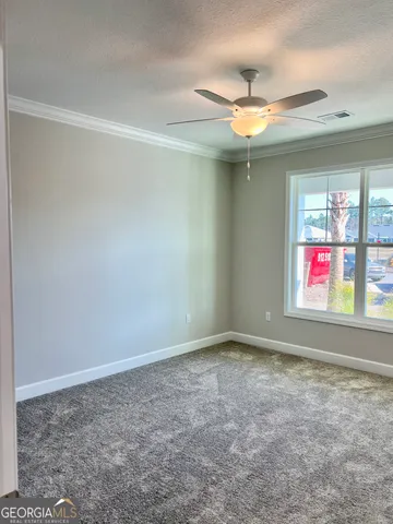 an empty room with windows and ceiling fan