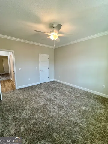 en empty room with ceiling fan and window