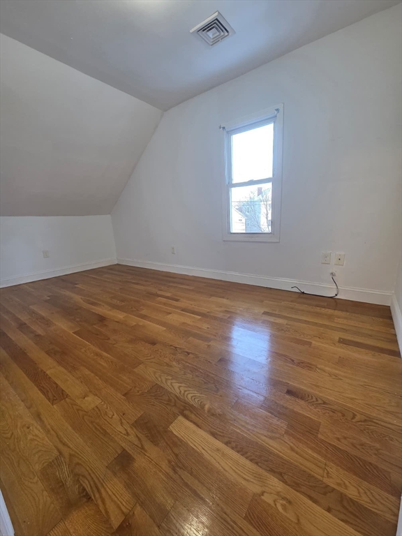 61 Crescent Avenue, Unit 2 Chelsea, MA 02150 - Photo 5 of 16 an empty room with wooden floor and windows