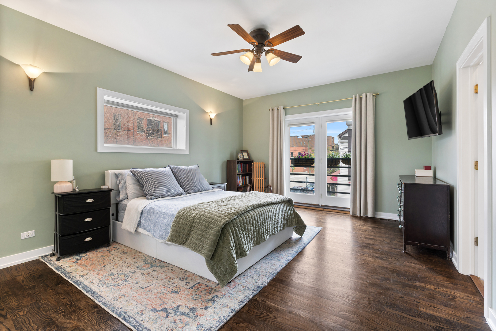 417 North Noble Street, Unit 5 Chicago, IL 60642 - Photo 11 of 15 a spacious bedroom with a bed and a flat screen tv