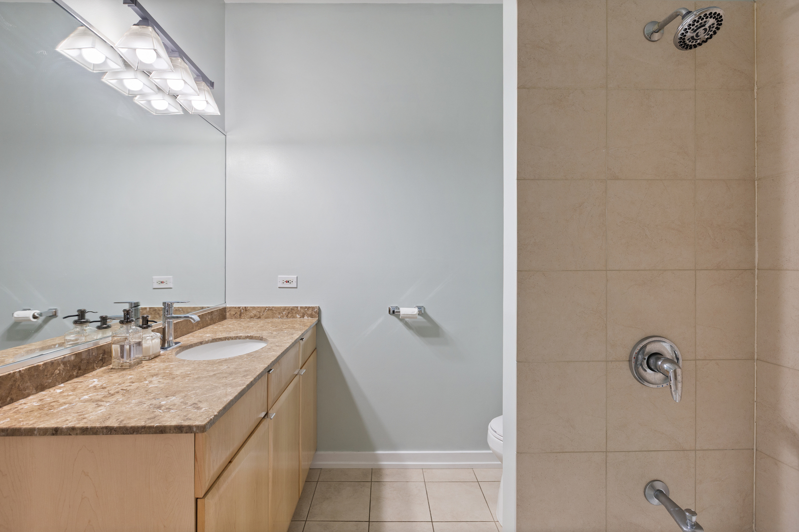 417 North Noble Street, Unit 5 Chicago, IL 60642 - Photo 14 of 15 a bathroom with a granite countertop sink a mirror and shower
