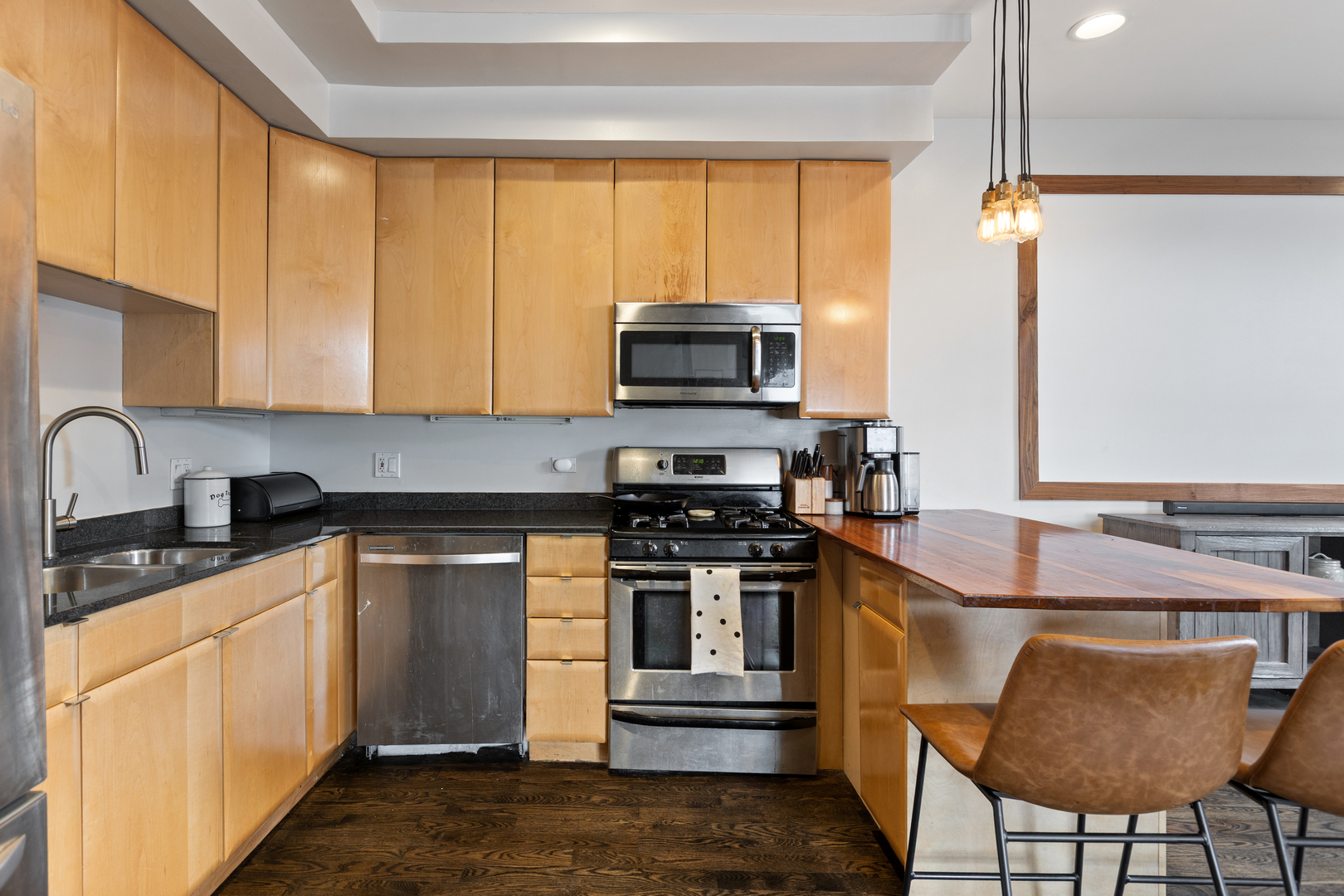 417 North Noble Street, Unit 5 Chicago, IL 60642 - Photo 5 of 15 a kitchen with stainless steel appliances granite countertop a stove a sink and a microwave