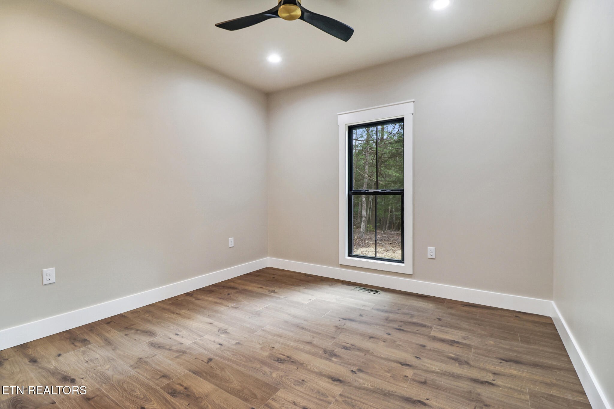 1440 Model Farm Road Jamestown, TN 38556 - Photo 28 of 35 an empty room with wooden floor ceiling fan and windows