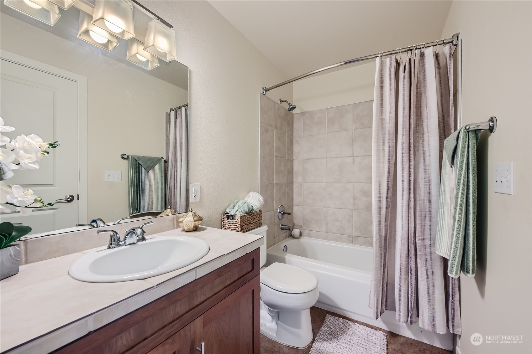 3901 243rd Place Southeast, Unit O203 Bothell, WA 98021 - Photo 7 of 11 a bathroom with a granite countertop sink toilet a mirror a vanity and shower