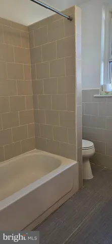 a white bath tub sitting next to a white toilet