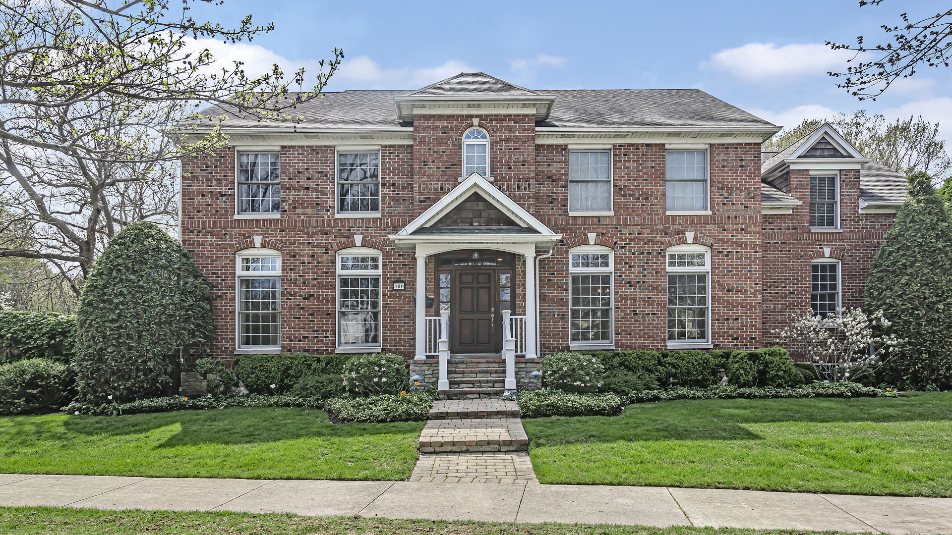 a front view of a house with yard and green space
