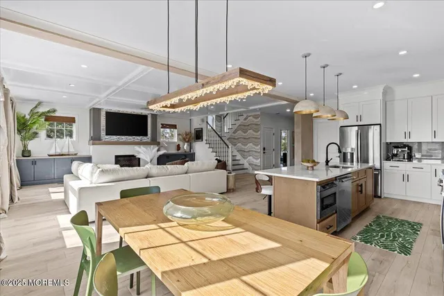 a living room with furniture kitchen view and a large window