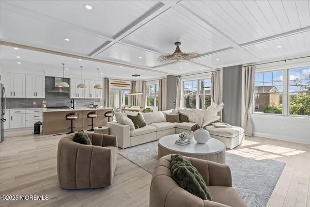 a kitchen with stainless steel appliances granite countertop a stove a sink a dining table and chairs with wooden floor