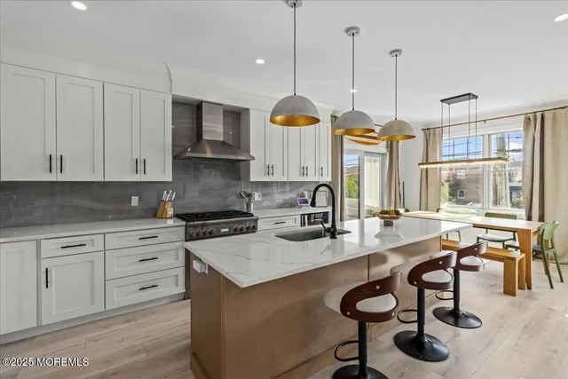 a kitchen with stainless steel appliances granite countertop a stove and a white cabinets