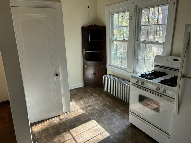 a kitchen with a refrigerator and white cabinets