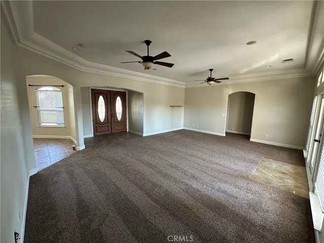 en empty room with windows and ceiling fan