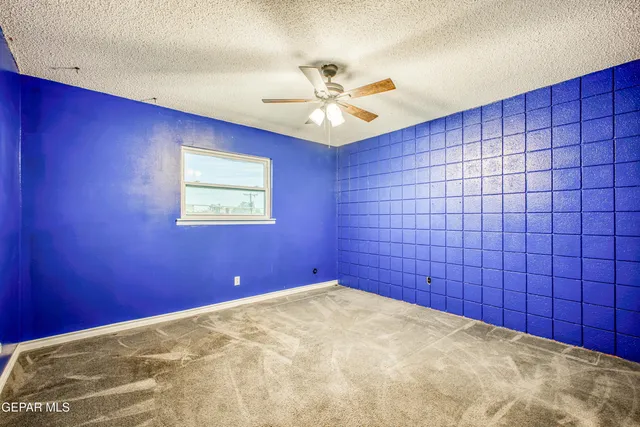 a view of a big room with a ceiling fan and a window
