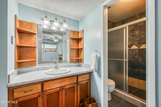 a bathroom with a granite countertop sink toilet and shower