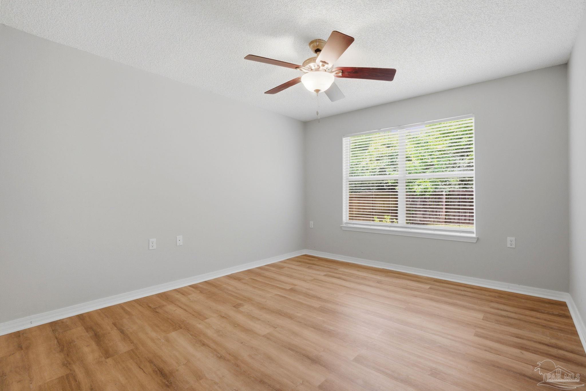 10120 Crest Ridge Drive Pensacola, FL 32514 - Photo 25 of 38 a view of an empty room with wooden floor and a window