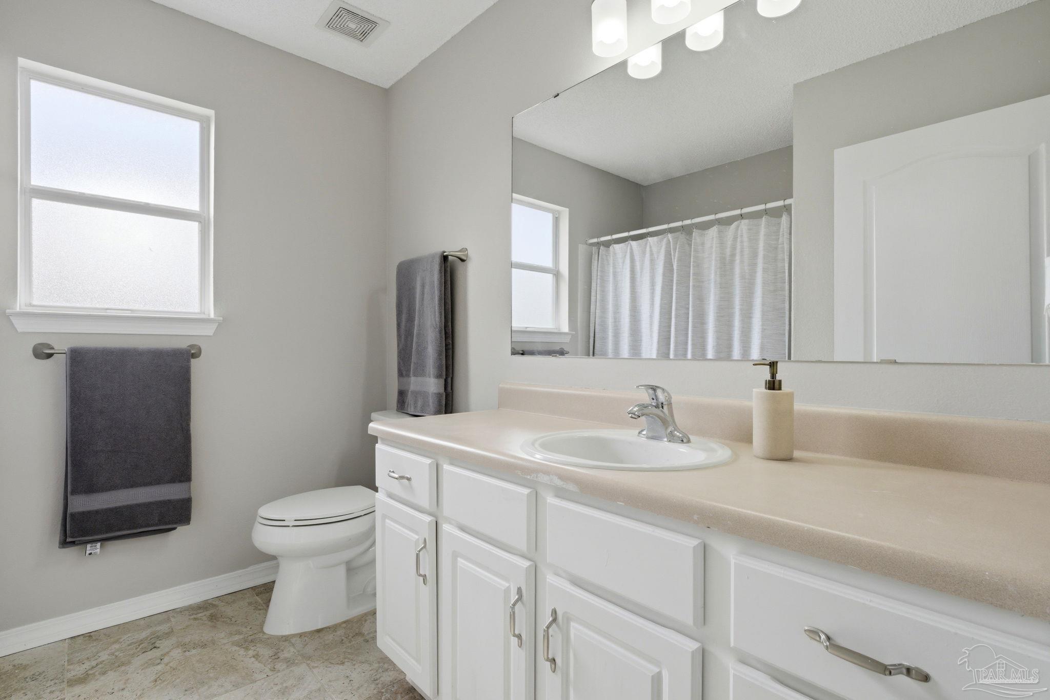 10120 Crest Ridge Drive Pensacola, FL 32514 - Photo 29 of 38 a bathroom with a toilet sink and mirror