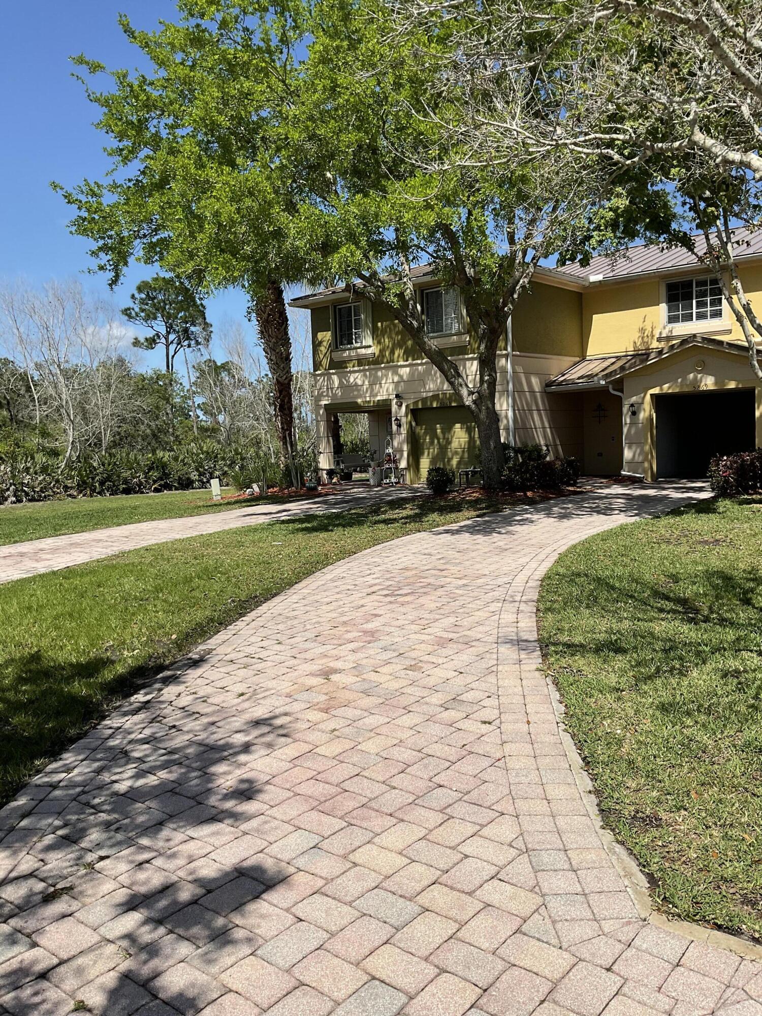 a front view of a house with a yard and trees