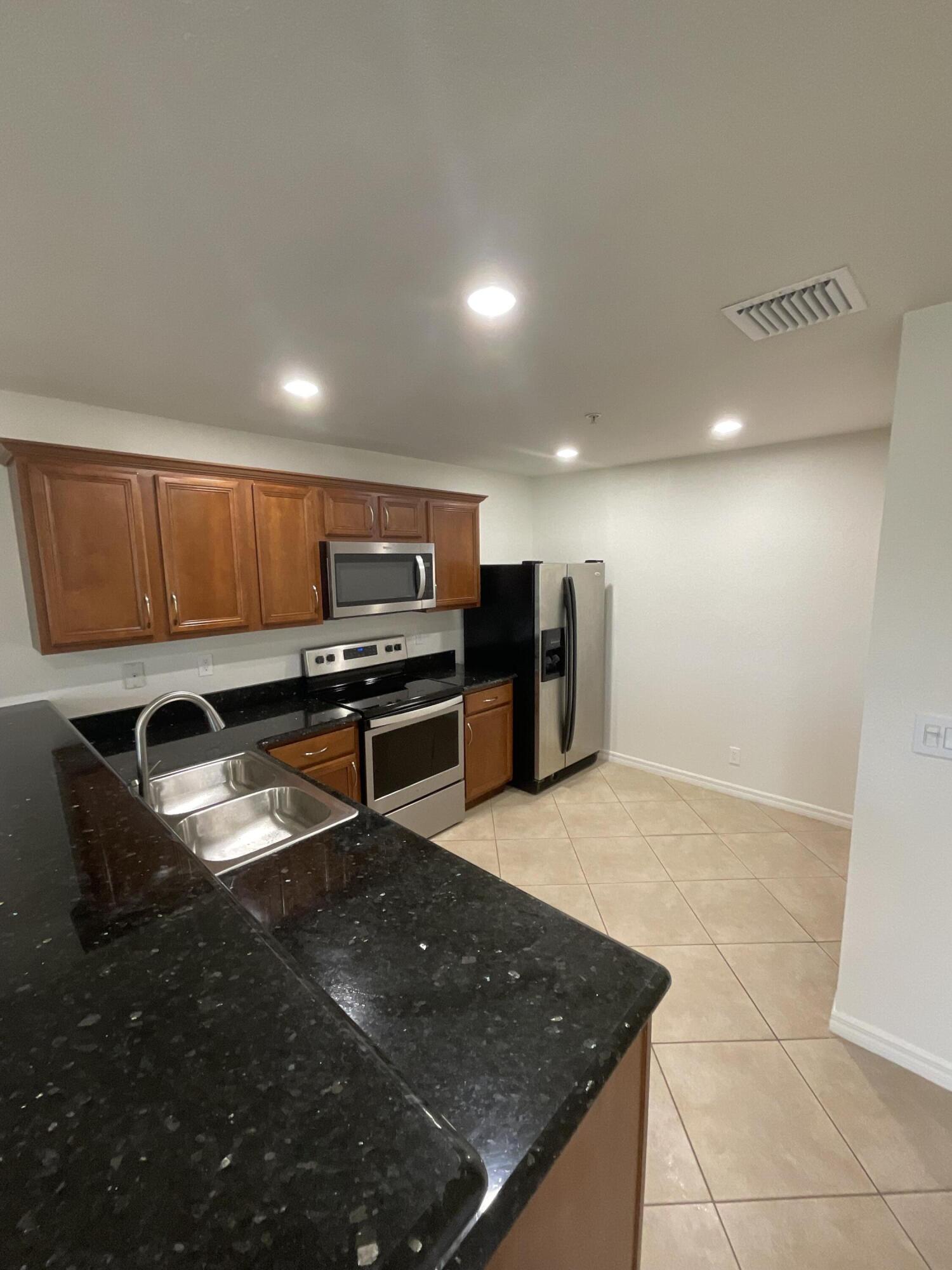 5269 Southeast Jennings Lane Stuart, FL 34997 - Photo 11 of 34 a kitchen with stainless steel appliances granite countertop a sink a stove and a refrigerator