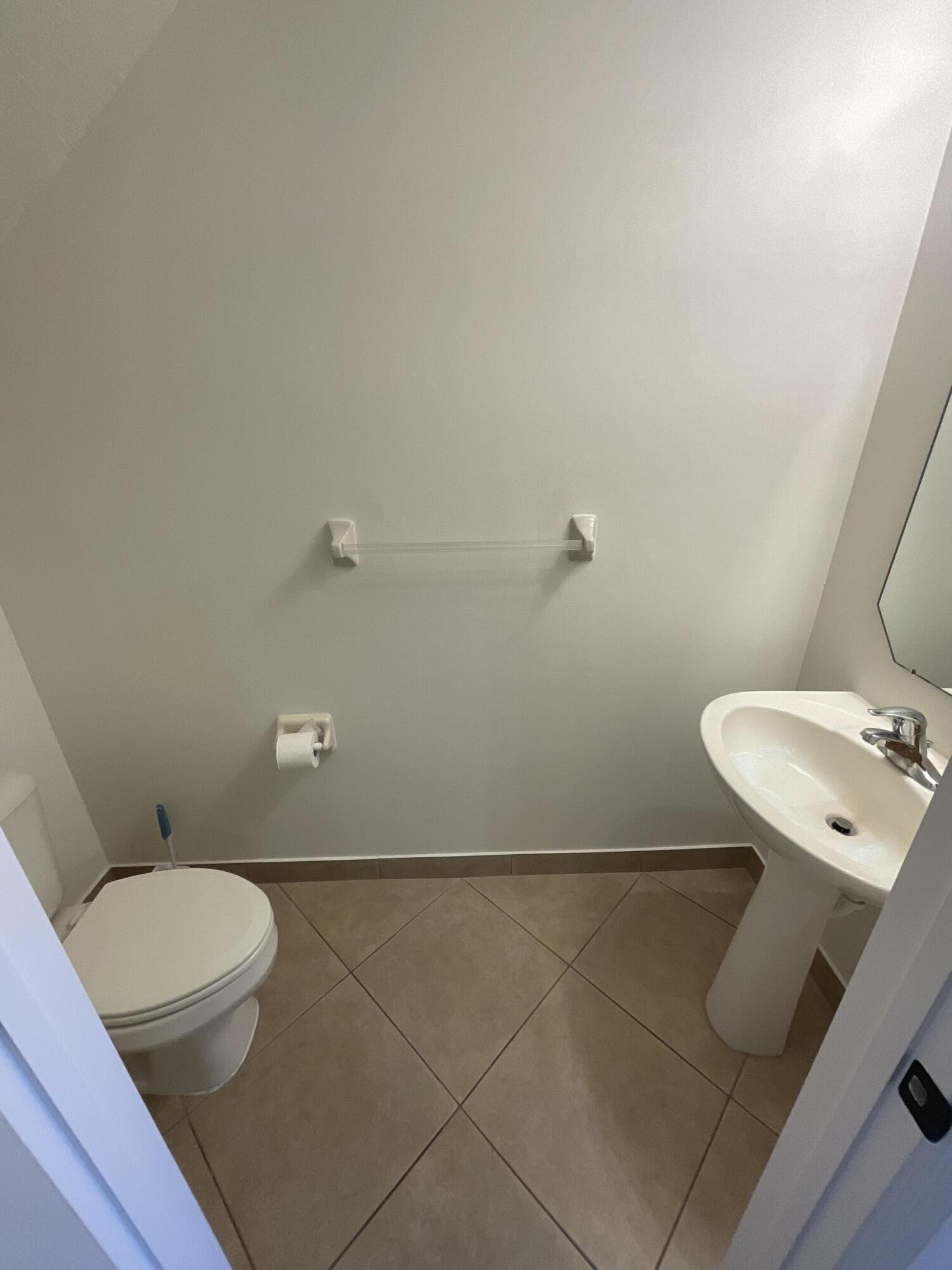 5269 Southeast Jennings Lane Stuart, FL 34997 - Photo 12 of 34 a bathroom with a sink a toilet and a mirror