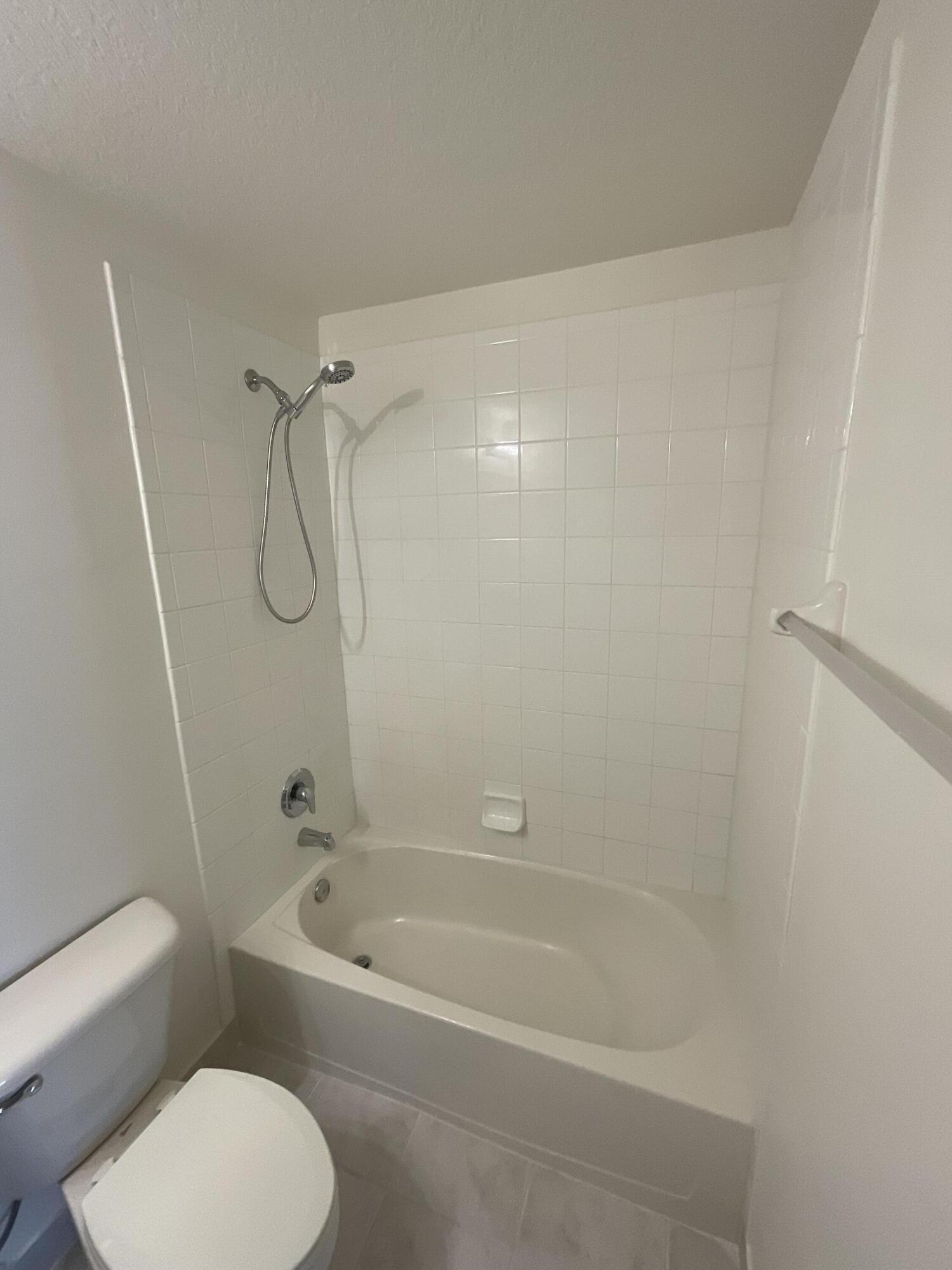 5269 Southeast Jennings Lane Stuart, FL 34997 - Photo 15 of 34 a bathroom with a toilet and a bath tub