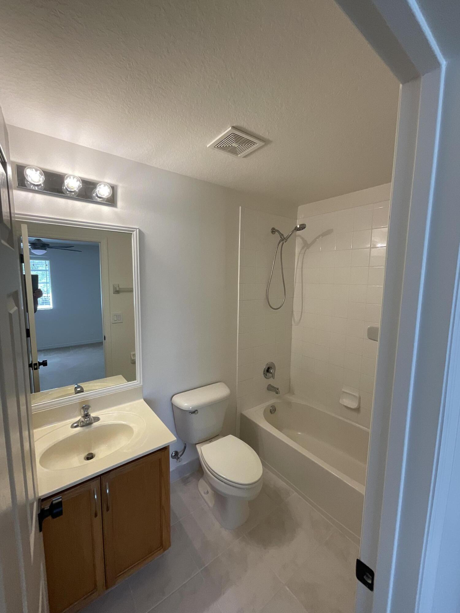 5269 Southeast Jennings Lane Stuart, FL 34997 - Photo 16 of 34 a bathroom with a sink a toilet and shower