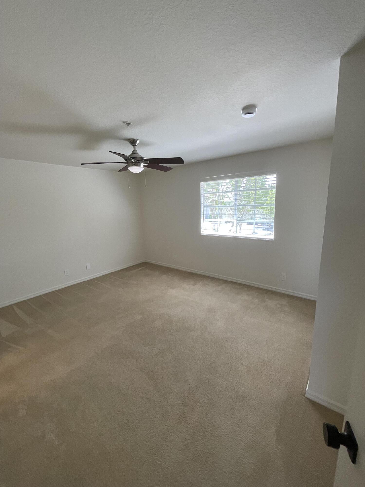5269 Southeast Jennings Lane Stuart, FL 34997 - Photo 33 of 34 an empty room with windows and fan