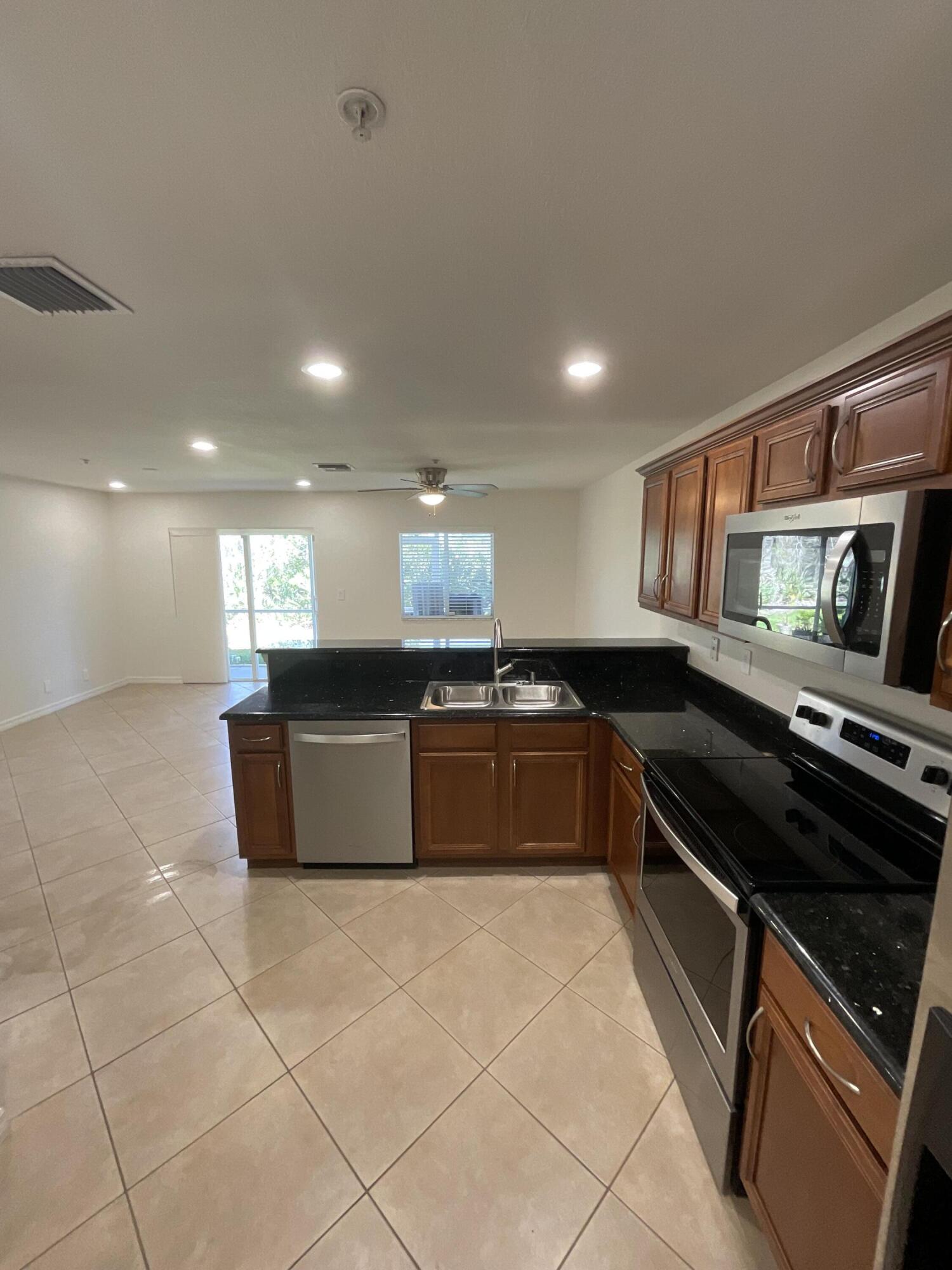 5269 Southeast Jennings Lane Stuart, FL 34997 - Photo 8 of 34 a large kitchen with granite countertop a stove and a sink