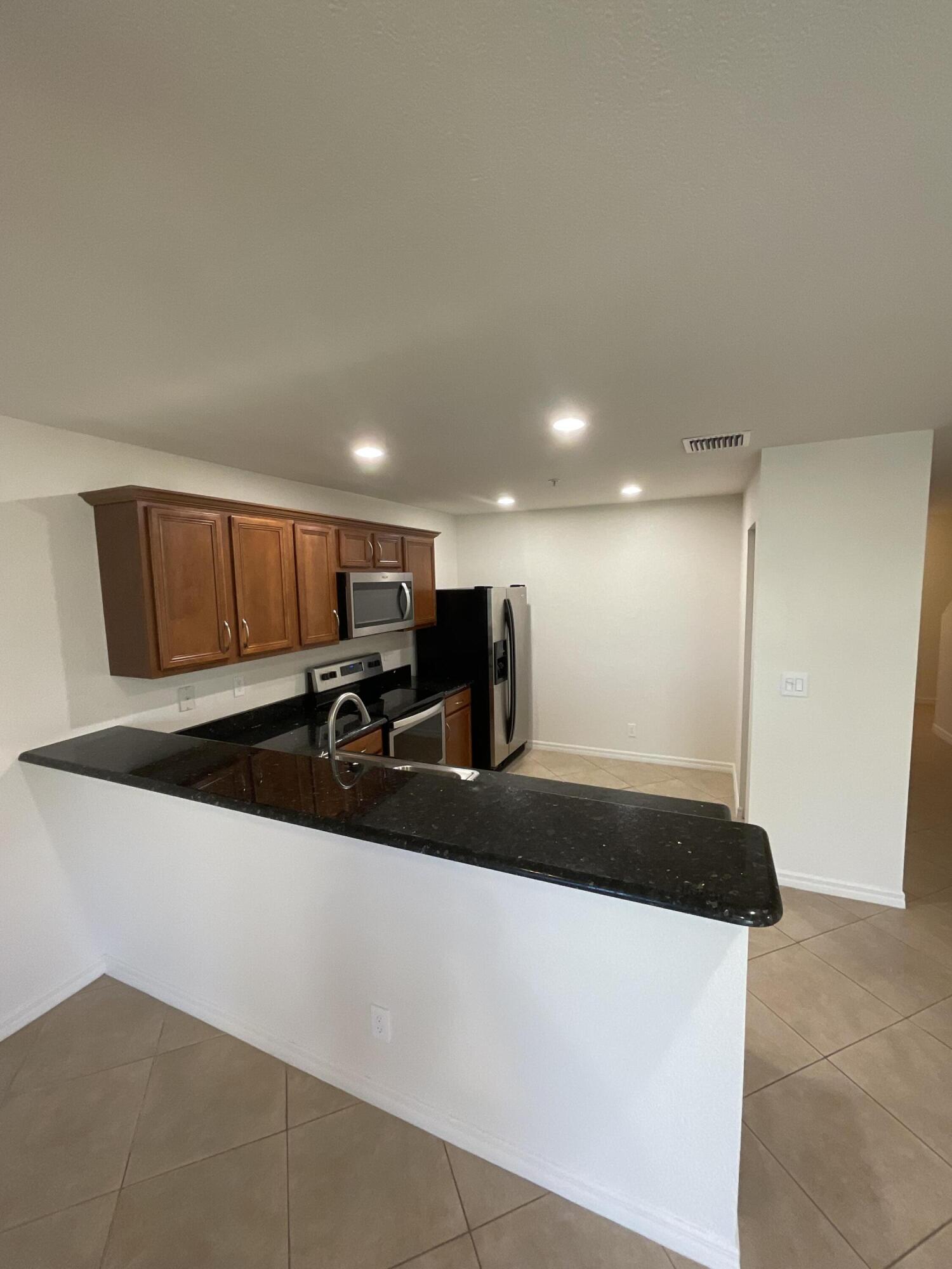 5269 Southeast Jennings Lane Stuart, FL 34997 - Photo 9 of 34 a living room with stainless steel appliances kitchen island a sink a stove and a refrigerator