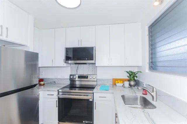 a kitchen with a sink a stove and a microwave