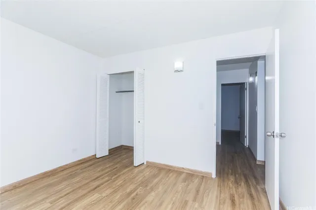 a view of an empty room with closet and a window
